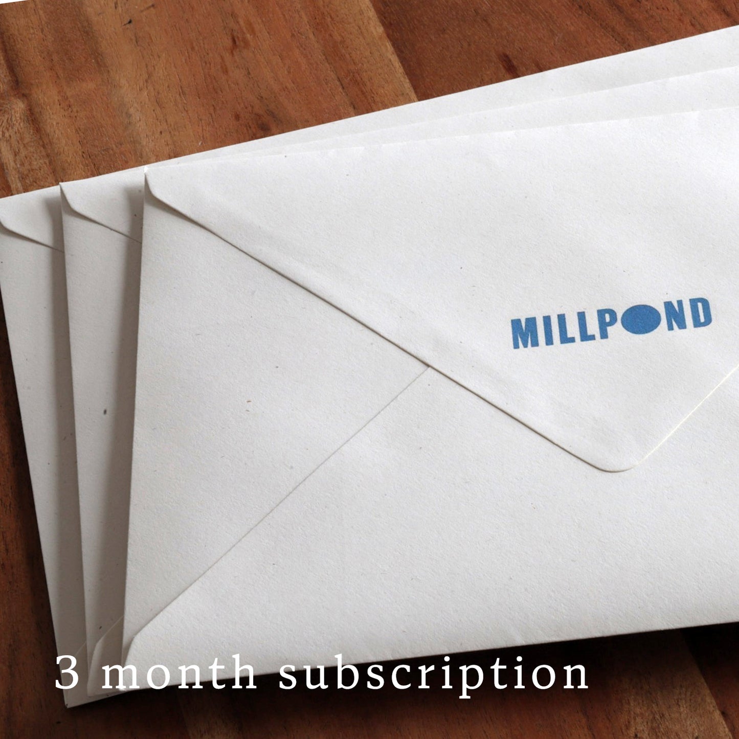 3 envelopes with 'MILLPOUND' branding on a wooden surface, labeled for a 3-month subscription.