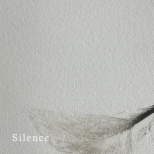 Text 'Silence' on a textured quality paper with a partially visible part of a feather in the bottom section